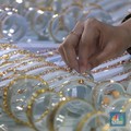 Karyawati menunjukkan emas Pegadaian di salah satu galeri 24 Pegadaian, Salemba Jakarta, Kamis (4/5). (CNBC Indonesia/Muhammad Sabki)