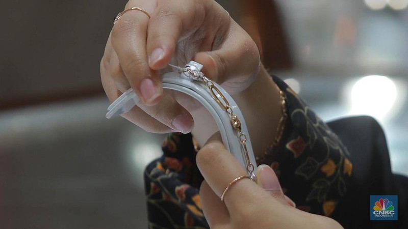 Karyawati menunjukkan emas PT Aneka Tambang Tbk. (Antam) di salah satu gallery penjualan emas di Jakarta, Kamis (4/5). (CNBC Indonesia/Muhammad Sabki)