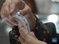 Karyawati menunjukkan emas Pegadaian di salah satu galeri 24 Pegadaian, Salemba Jakarta, Kamis (4/5). (CNBC Indonesia/Muhammad Sabki)