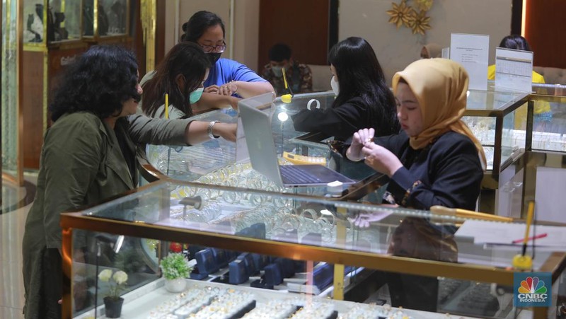 Karyawati menunjukkan emas PT Aneka Tambang Tbk. (Antam) di salah satu gallery penjualan emas di Jakarta, Kamis (4/5). (CNBC Indonesia/Muhammad Sabki)