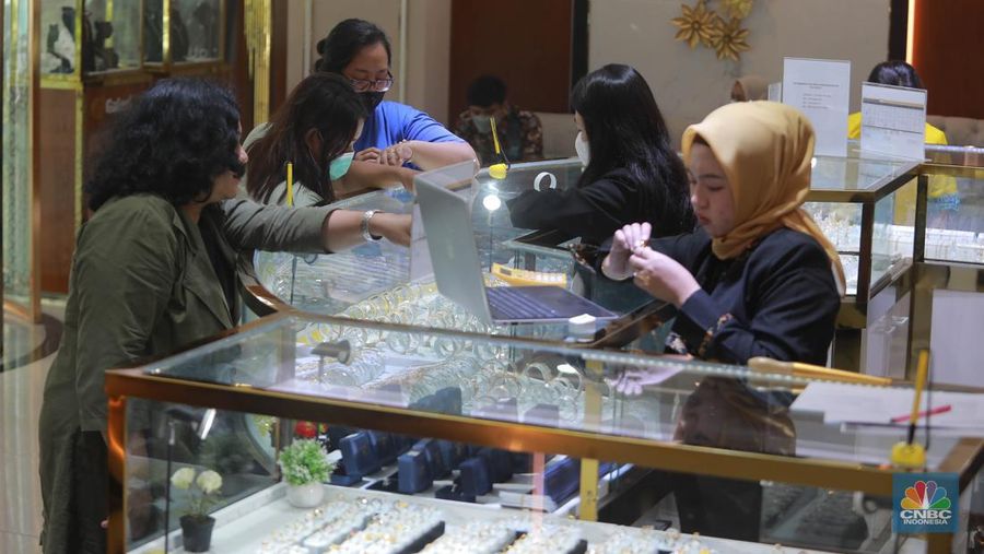 Karyawati menunjukkan emas Pegadaian di salah satu galeri 24 Pegadaian, Salemba Jakarta, Kamis (4/5). (CNBC Indonesia/Muhammad Sabki)