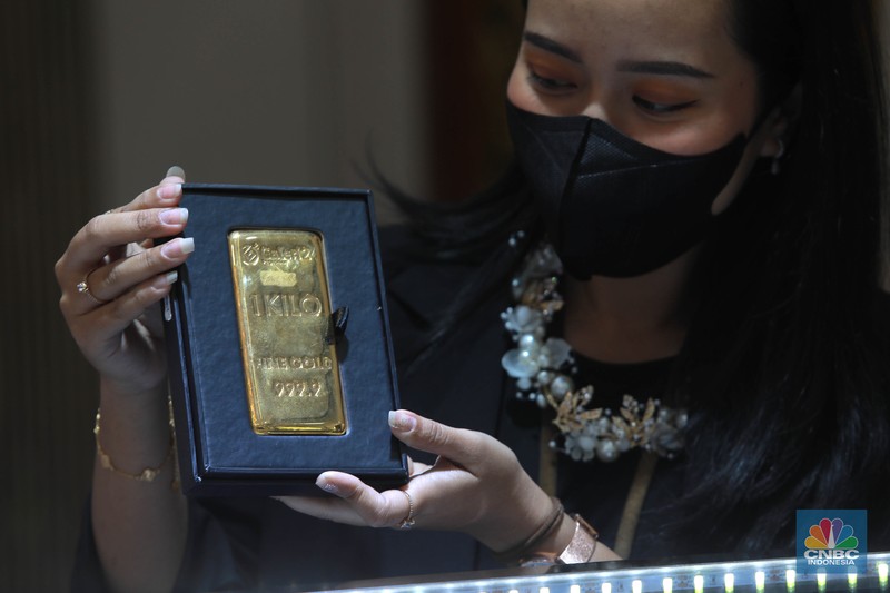 Karyawati menunjukkan emas PT Aneka Tambang Tbk. (Antam) di salah satu gallery penjualan emas di Jakarta, Kamis (4/5). (CNBC Indonesia/Muhammad Sabki)