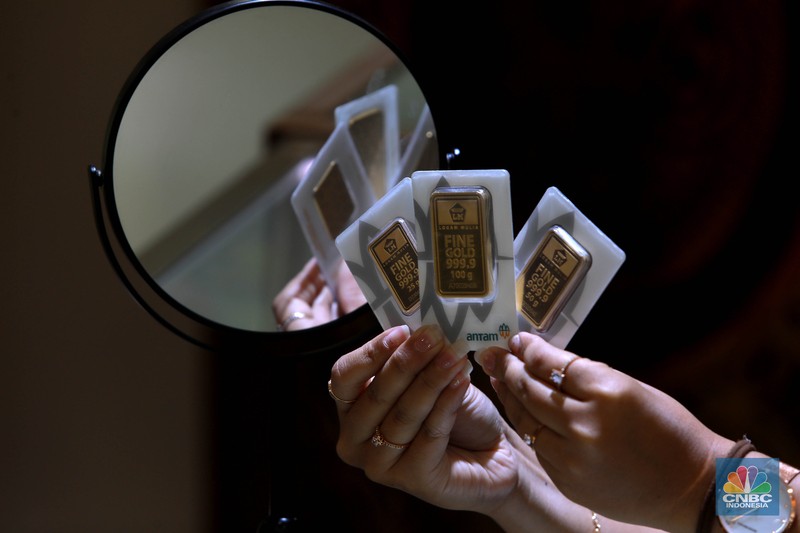 Karyawati menunjukkan emas PT Aneka Tambang Tbk. (Antam) di salah satu gallery penjualan emas di Jakarta, Kamis (4/5). (CNBC Indonesia/Muhammad Sabki)