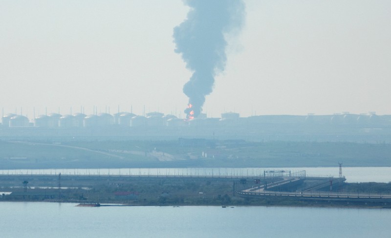 Petugas memadamkan kilang minyak yang terbakar menggunakan pesawat tanpa awak di Krimea, Ukraina, Rabu (3/5/2023) waktu setempat. Petugas memadamkan kilang minyak yang terbakar menggunakan pesawat tanpa awak di Karasnodar, Rusia, Rabu (3/5/2023) waktu setempat. (Russian Emergency Ministry Press Service via AP)