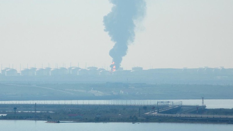 Petugas memadamkan kilang minyak yang terbakar menggunakan pesawat tanpa awak di Karasnodar, Rusia, Rabu (3/5/2023) waktu setempat. (Russian Emergency Ministry Press Service via AP)