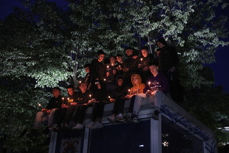 Seorang wanita mnaruh boneka saat menghadiri aksi menyalakan lilin dan tabur bunga pasca tragedi penembakan pada Sekolah Dasar di Kota Belgrade, Serbia, Rabu (3/5/2023) malam. (REUTERS/Antonio Bronic)