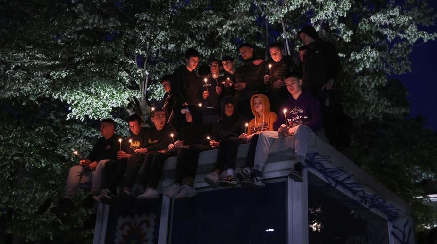 Seorang wanita mnaruh boneka saat menghadiri aksi menyalakan lilin dan tabur bunga pasca tragedi penembakan pada Sekolah Dasar di Kota Belgrade, Serbia, Rabu (3/5/2023) malam. (REUTERS/Antonio Bronic)