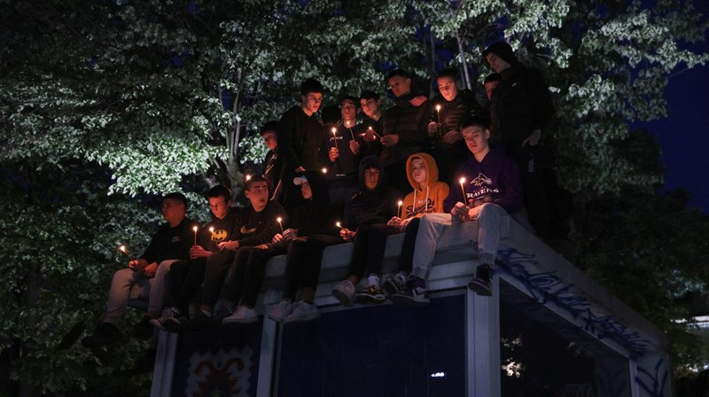 Seorang wanita mnaruh boneka saat menghadiri aksi menyalakan lilin dan tabur bunga pasca tragedi penembakan pada Sekolah Dasar di Kota Belgrade, Serbia, Rabu (3/5/2023) malam. (REUTERS/Antonio Bronic)