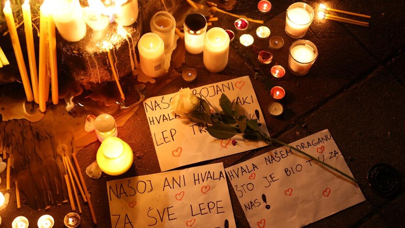 Seorang wanita mnaruh boneka saat menghadiri aksi menyalakan lilin dan tabur bunga pasca tragedi penembakan pada Sekolah Dasar di Kota Belgrade, Serbia, Rabu (3/5/2023) malam. (REUTERS/Antonio Bronic)