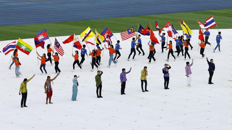 Pesta Olahraga Asia Tenggara - Upacara Pembukaan - Stadion Nasional Morodok Techo, Phnom Penh, Kamboja - 5 Mei 2023 Para pengisi acara membawa bendera negara peserta selama upacara pembukaan. (REUTERS/Kim Kyung-Hoon)