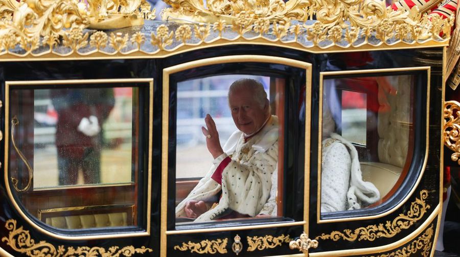 Raja Charles III menyapa dari dalam kerta kudamenjelang penobatan di London, Inggris, Sabtu (6/5/2023).