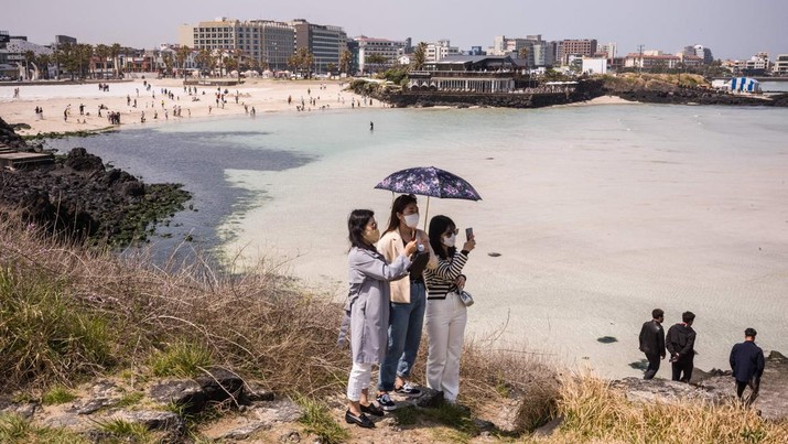 Warga berswafoto di Jeju Island (AFP via Getty Images/ANTHONY WALLACE)