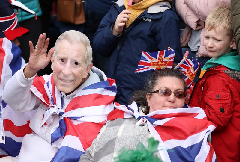 Warga saat menghadiri penobatan Raja Charles III dan Ratu Camilia dari luar Westminster Abbey, London, Inggri, Sabtu (6/5/20023). (REUTERS
