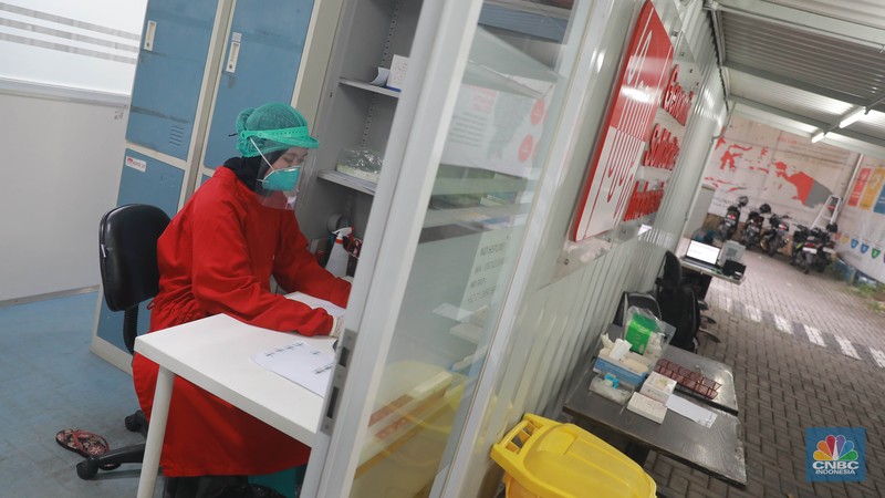 Petugas medis menunggu pengguna jasa layanan 'drive thru' tes antigen dan PCR COVID-19 harian di salah satu laboratorium di Tb Simatupang, Jakarta, Senin (8/5/2023).  (CNBC Indonesia/Muhammad Sabki)