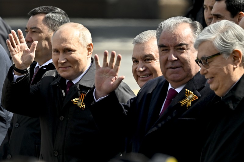 Presiden Rusia Vladimir Putin melambaikan tangan sambil tersenyum saat menghadiri Hari Kemenangan Rusia di Moskow, Rusia, Selasa (9/5/2023). (Getty Images)