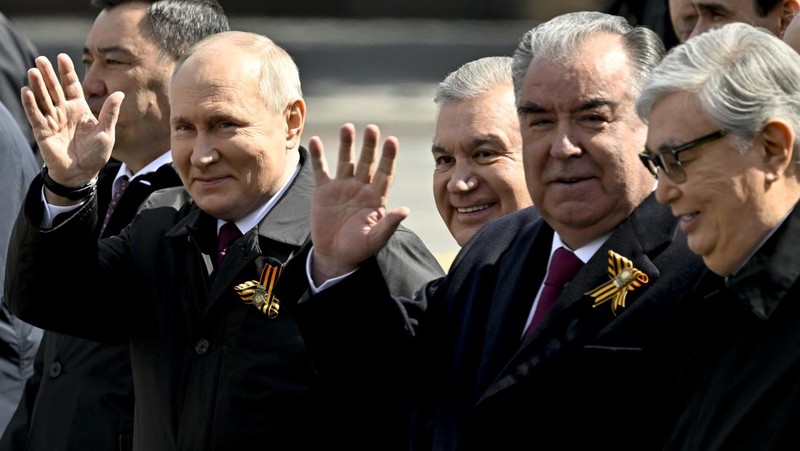 Presiden Rusia Vladimir Putin melambaikan tangan sambil tersenyum saat menghadiri Hari Kemenangan Rusia di Moskow, Rusia, Selasa (9/5/2023). (Getty Images)