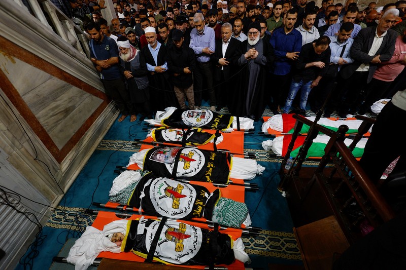 Pelayatb mensalatkan jenazah senior Jihad Islam Palestina Tareq Izzeldeen dan Khalil Al-Bahtini, dan warga Palestina lainnya yang tewas dalam serangan Israe di Kota Gaza, Palestina, Selasa (9/5/2023). (REUTERS/MOHAMMED SALEM)