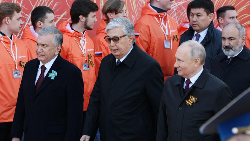Presiden Rusia Vladimir Putin melambaikan tangan sambil tersenyum saat menghadiri Hari Kemenangan Rusia di Moskow, Rusia, Selasa (9/5/2023). (Getty Images)