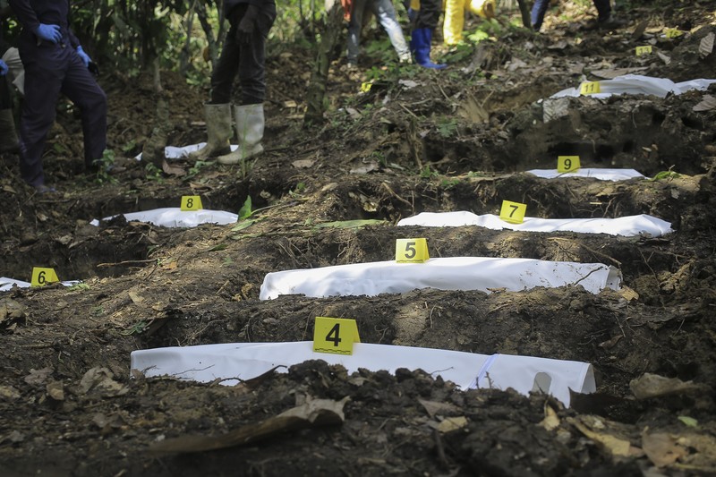 Petugas forensik memeriksa jenazah manusia pada lokasi penemujan kuburan massal di desa Ndoma, dekat Beni di Kivu Utara, Kongo, Sabtu (6/5/2023). (AP Photo)