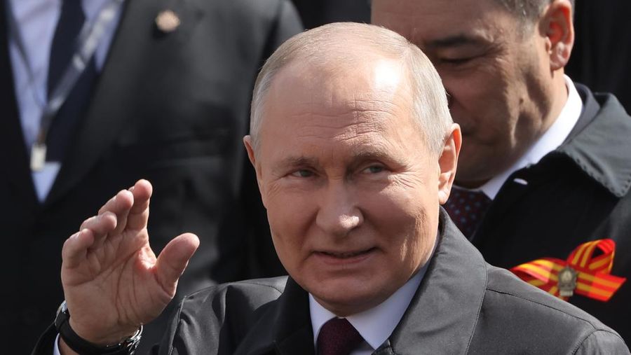 Presiden Rusia Vladimir Putin melambaikan tangan sambil tersenyum saat menghadiri Hari Kemenangan Rusia di Moskow, Rusia, Selasa (9/5/2023). (Getty Images)