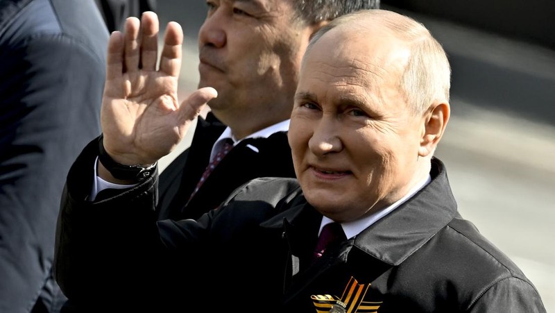 Presiden Rusia Vladimir Putin melambaikan tangan sambil tersenyum saat menghadiri Hari Kemenangan Rusia di Moskow, Rusia, Selasa (9/5/2023). (Getty Images)