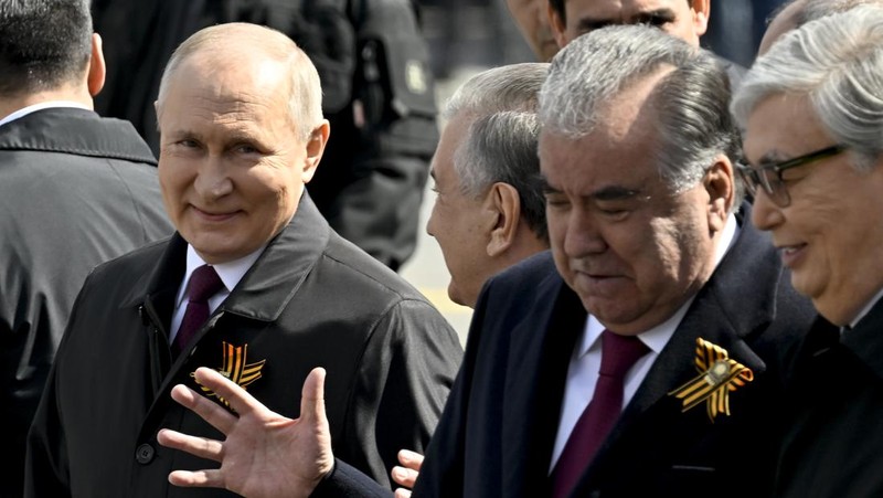 Presiden Rusia Vladimir Putin melambaikan tangan sambil tersenyum saat menghadiri Hari Kemenangan Rusia di Moskow, Rusia, Selasa (9/5/2023). (Getty Images)