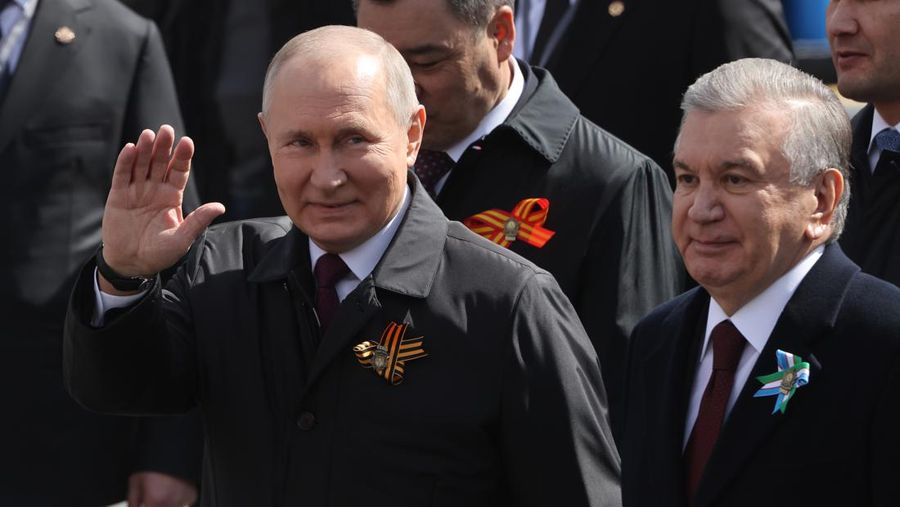 Presiden Rusia Vladimir Putin melambaikan tangan sambil tersenyum saat menghadiri Hari Kemenangan Rusia di Moskow, Rusia, Selasa (9/5/2023). (Getty Images)