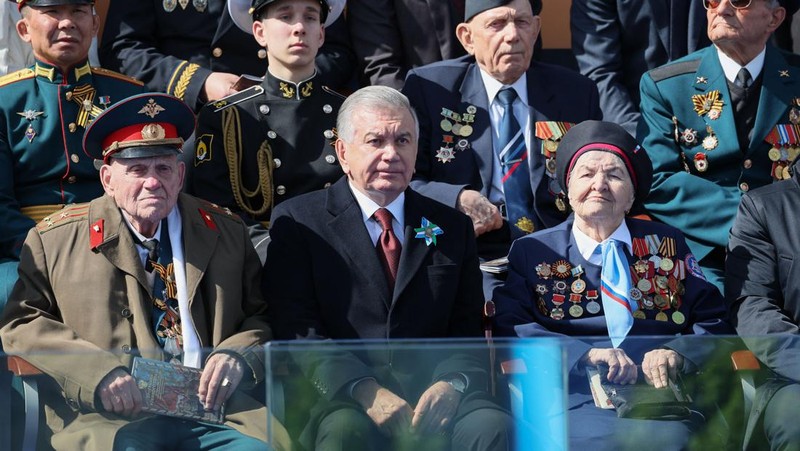 Presiden Rusia Vladimir Putin melambaikan tangan sambil tersenyum saat menghadiri Hari Kemenangan Rusia di Moskow, Rusia, Selasa (9/5/2023). (Getty Images)