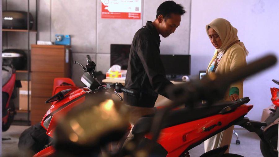 Seorang sales motor menjelaskan motor listrik di salah satu showroom motor di Kawasan Bintaro, Jakarta Selatan, Selasa,(9/5/2023). (CNBC Indonesia/Muhammad Sabki)