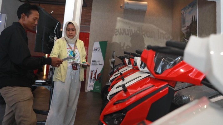 Seorang sales motor menjelaskan motor listrik di salah satu showroom motor di Kawasan Bintaro, Jakarta Selatan, Selasa,(9/5/2023). (CNBC Indonesia/Muhammad Sabki)