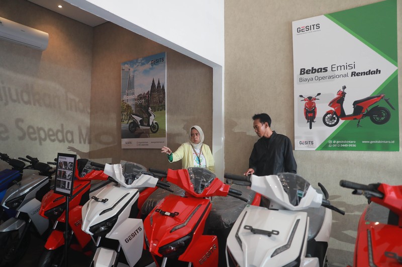 Seorang sales motor menjelaskan motor listrik di salah satu showroom motor di Kawasan Bintaro, Jakarta Selatan, Selasa,(9/5/2023). (CNBC Indonesia/Muhammad Sabki)