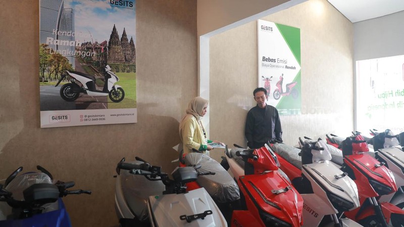 Seorang sales motor menjelaskan motor listrik di salah satu showroom motor di Kawasan Bintaro, Jakarta Selatan, Selasa,(9/5/2023). (CNBC Indonesia/Muhammad Sabki)