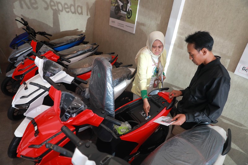 Seorang sales motor menjelaskan motor listrik di salah satu showroom motor di Kawasan Bintaro, Jakarta Selatan, Selasa,(9/5/2023). (CNBC Indonesia/Muhammad Sabki)