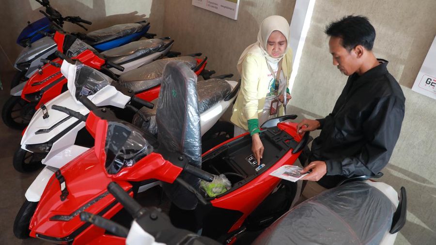 Seorang sales motor menjelaskan motor listrik di salah satu showroom motor di Kawasan Bintaro, Jakarta Selatan, Selasa,(9/5/2023). (CNBC Indonesia/Muhammad Sabki)