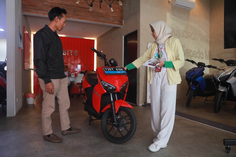 Seorang sales motor menjelaskan motor listrik di salah satu showroom motor di Kawasan Bintaro, Jakarta Selatan, Selasa,(9/5/2023). Seorang sales motor menjelaskan motor listrik di salah satu showroom motor di Kawasan Bintaro, Jakarta Selatan, Selasa,(9/5/2023). (CNBC Indonesia/Muhammad Sabki)