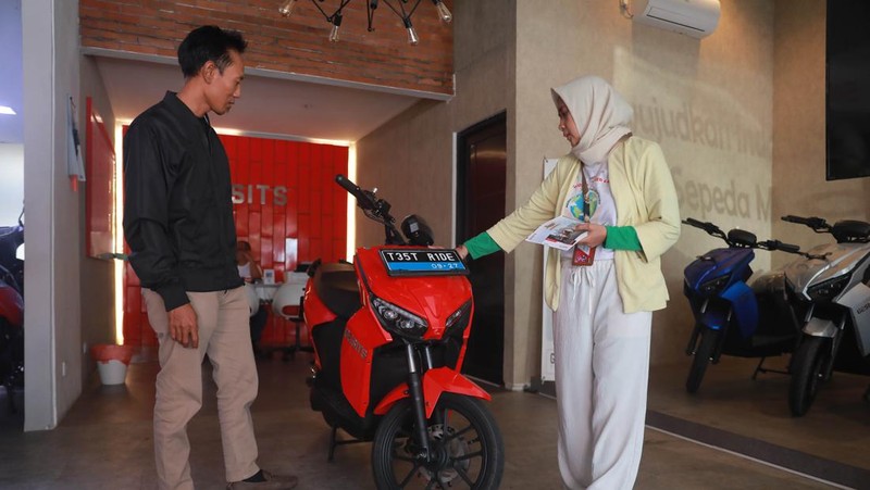 Seorang sales motor menjelaskan motor listrik di salah satu showroom motor di Kawasan Bintaro, Jakarta Selatan, Selasa,(9/5/2023). (CNBC Indonesia/Muhammad Sabki)