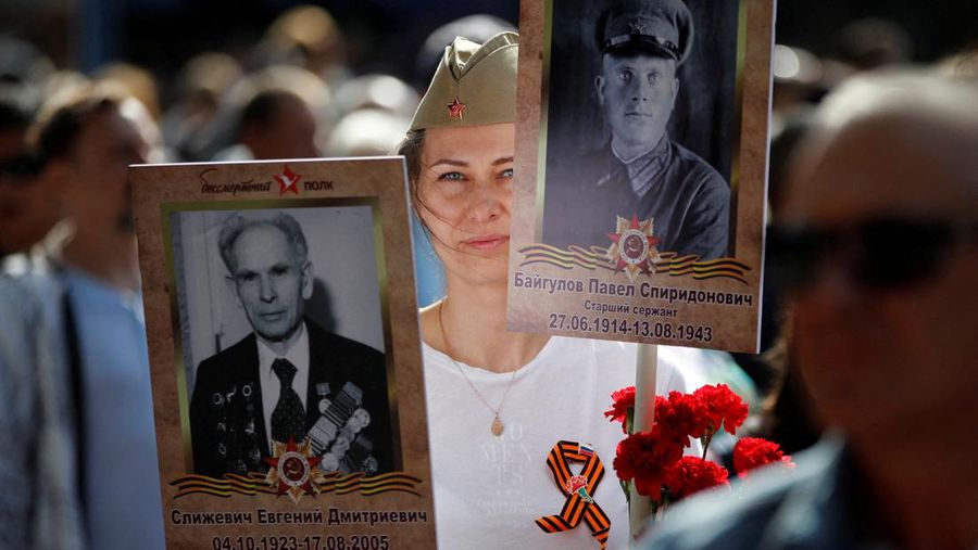 Seorang wanita membawa potret tentara Tentara saat upacara peringatan 78 tahun Hari Kemenangan di Lapangan Merah di Moskow, Rusia, Selasa (9/5/2023). (REUTERS/Pavel Mikheyev)