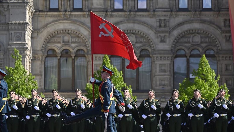 Seorang wanita membawa potret tentara Tentara saat upacara peringatan 78 tahun Hari Kemenangan di Lapangan Merah di Moskow, Rusia, Selasa (9/5/2023). (REUTERS/Pavel Mikheyev)