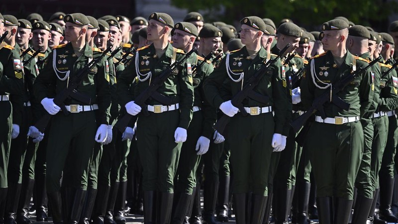Seorang wanita membawa potret tentara Tentara saat upacara peringatan 78 tahun Hari Kemenangan di Lapangan Merah di Moskow, Rusia, Selasa (9/5/2023). (REUTERS/Pavel Mikheyev)