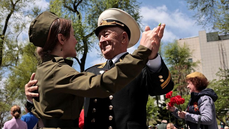 Seorang wanita membawa potret tentara Tentara saat upacara peringatan 78 tahun Hari Kemenangan di Lapangan Merah di Moskow, Rusia, Selasa (9/5/2023). (REUTERS/Pavel Mikheyev)