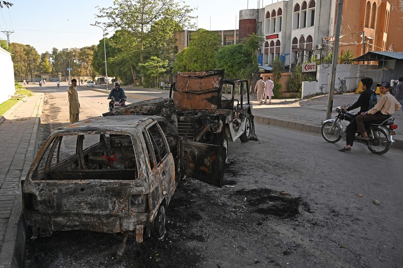 Seorang pria melintasi jalan melewati barikade yang dibakar oleh para pendukung mantan Perdana Menteri Pakistan Imran Khan selama protes terhadap penangkapannya, di Karachi, Pakistan, Selasa (9/5/2023). Seorang pria melintasi jalan melewati barikade yang dibakar oleh para pendukung mantan Perdana Menteri Pakistan Imran Khan selama protes terhadap penangkapannya, di Karachi, Pakistan, Selasa (9/5/2023). (REUTERS/AKHTAR SOOMRO)