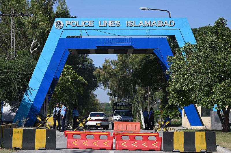 Seorang pria melintasi jalan melewati barikade yang dibakar oleh para pendukung mantan Perdana Menteri Pakistan Imran Khan selama protes terhadap penangkapannya, di Karachi, Pakistan, Selasa (9/5/2023). (REUTERS/AKHTAR SOOMRO)