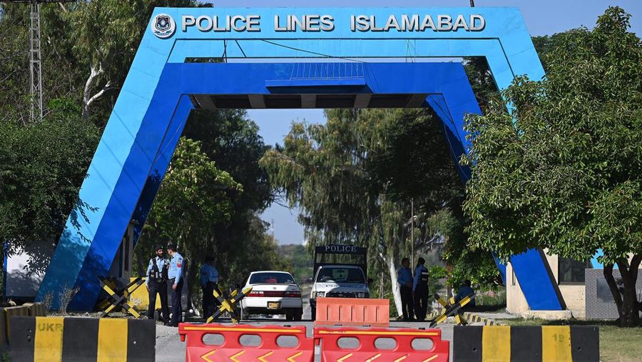 Seorang pria melintasi jalan melewati barikade yang dibakar oleh para pendukung mantan Perdana Menteri Pakistan Imran Khan selama protes terhadap penangkapannya, di Karachi, Pakistan, Selasa (9/5/2023). (REUTERS/AKHTAR SOOMRO)