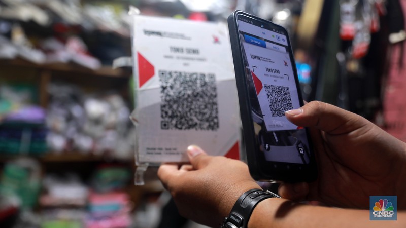 Seorang pedagang ikan asin menyiapkan dagangan dengan menyediakan sistem pembayaran Quick Response Code Indonesia Standard (QRIS) di Kawasan Pasar Tradisionan Pasar Minggu, Jakarta, Kamis, (11/5). Seorang pedagang ikan asin menyiapkan dagangan dengan menyediakan sistem pembayaran Quick Response Code Indonesia Standard (QRIS) di Kawasan Pasar Tradisionan Pasar Minggu, Jakarta, Kamis, (11/5). (CNBC Indonesia/Muhammad Sabki)