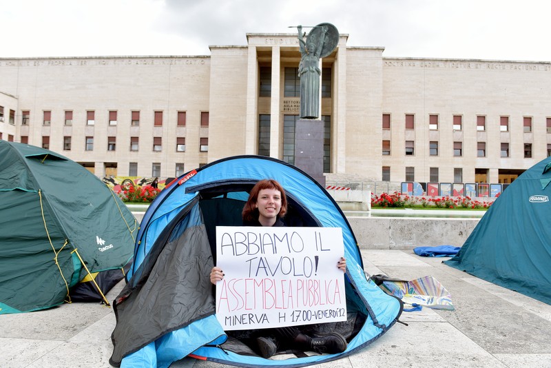 Mahasiswa Universitas La Sapienza melakukan aksi protes terkait tingginya biaya sewa hunian dengan mendirikan tenda dan berkemah di depan patung Minerva, Roma, Italia, Kamis (11/5/2023). Mahasiswa Universitas La Sapienza melakukan aksi protes terkait tingginya biaya sewa hunian dengan mendirikan tenda dan berkemah di depan patung Minerva, Roma, Italia, Kamis (11/5/2023). (Simona Granati - Corbis/Corbis via Getty Images)