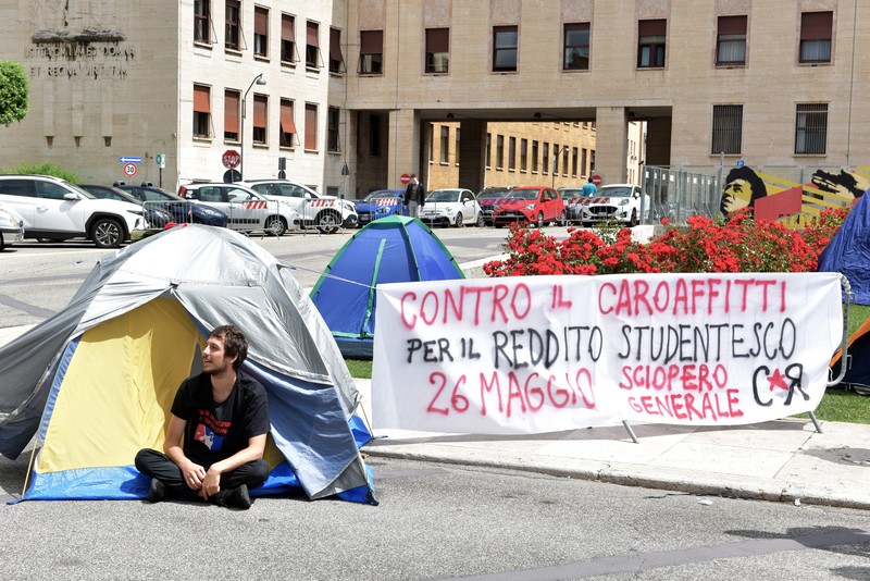 Mahasiswa Universitas La Sapienza melakukan aksi protes terkait tingginya biaya sewa hunian dengan mendirikan tenda dan berkemah di depan patung Minerva, Roma, Italia, Kamis (11/5/2023). Mahasiswa Universitas La Sapienza melakukan aksi protes terkait tingginya biaya sewa hunian dengan mendirikan tenda dan berkemah di depan patung Minerva, Roma, Italia, Kamis (11/5/2023). (Simona Granati - Corbis/Corbis via Getty Images)