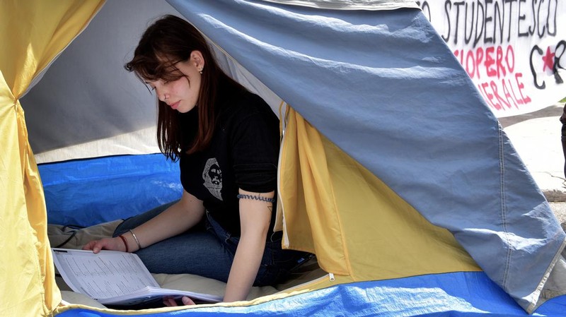 Mahasiswa Universitas La Sapienza melakukan aksi protes terkait tingginya biaya sewa hunian dengan mendirikan tenda dan berkemah di depan patung Minerva, Roma, Italia, Kamis (11/5/2023). (Simona Granati - Corbis/Corbis via Getty Images)