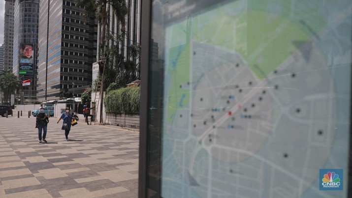Sejumlah pekerja melintas di jalur pedestrian di kawasan Senayan Sudirman, Jakarta, Jumat (12/5/2023). (CNBC Indonesia/Muhammad Sabki)