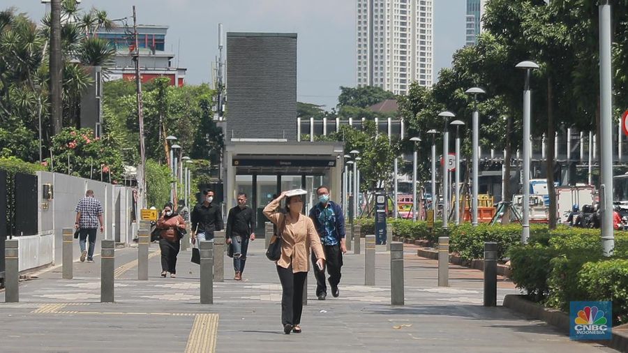 Sejumlah pekerja melintas di jalur pedestrian di kawasan Senayan Sudirman, Jakarta, Jumat (12/5/2023). (վ/Muhammad Sabki)