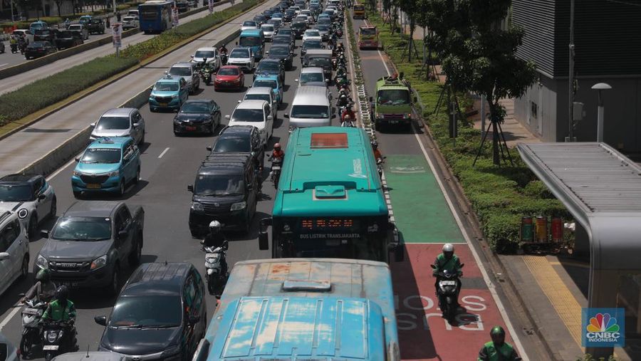 Sejumlah pekerja melintas di jalur pedestrian di kawasan Senayan Sudirman, Jakarta, Jumat (12/5/2023). (CNBC Indonesia/Muhammad Sabki)
